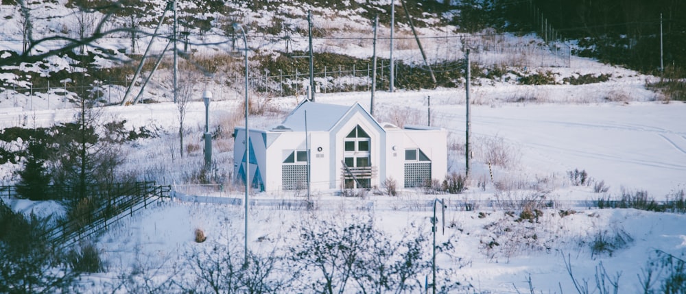 white and blue house on snow covered ground