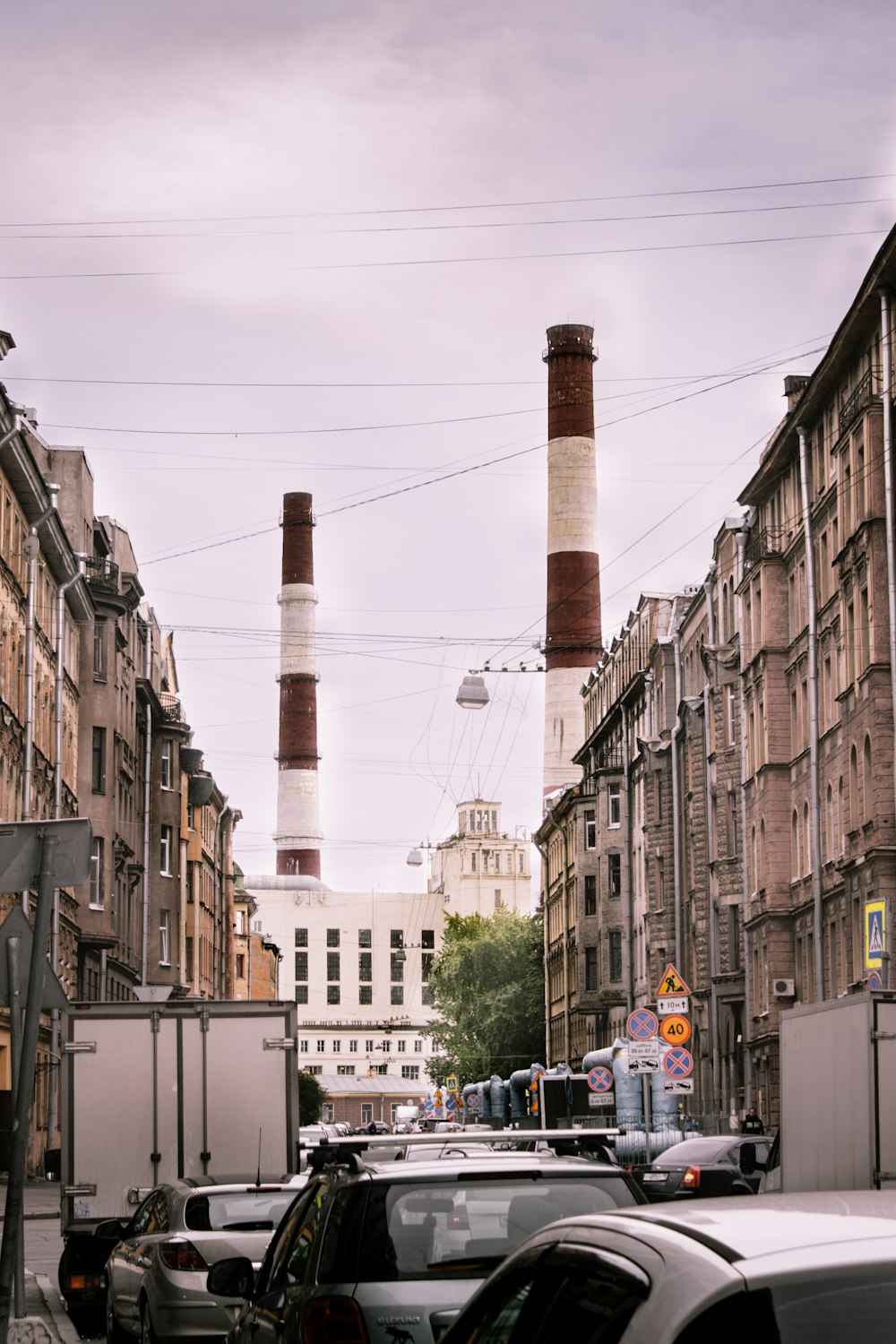 cars parked on side of the road in between buildings during daytime