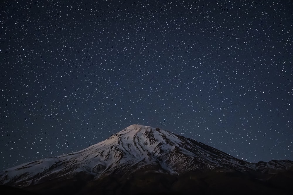 black and white mountain under starry night