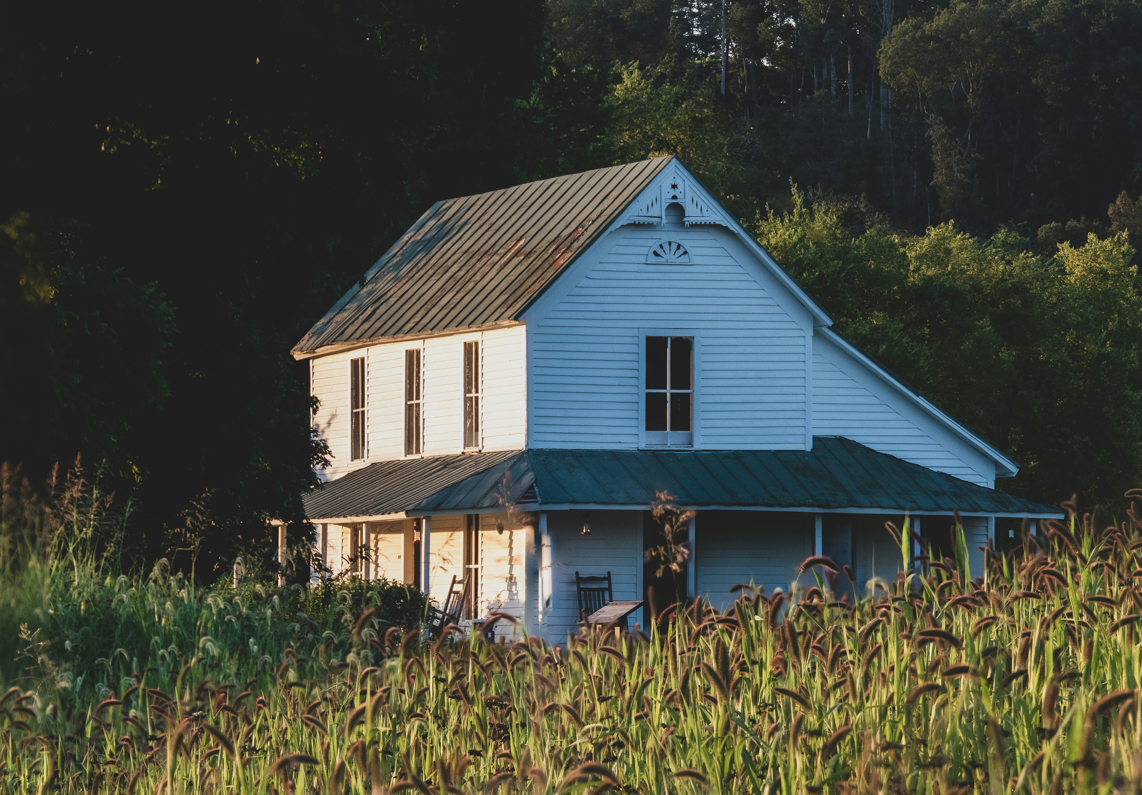 An old farmhouse sits among the fields just before sunset.