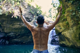 man in blue denim shorts standing near body of water during daytime