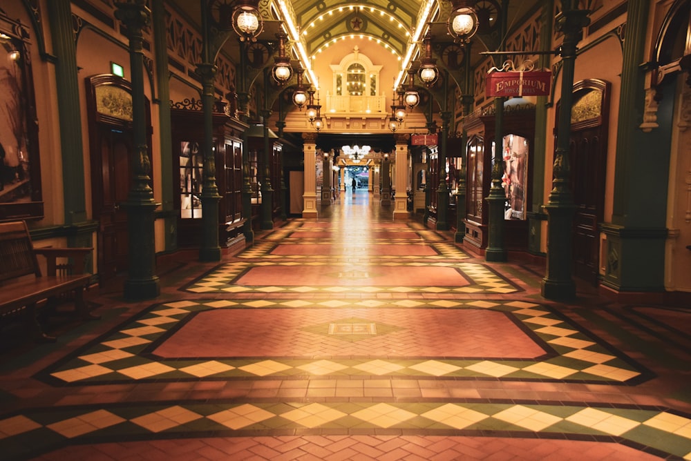 people walking on hallway with red and brown carpet