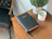 A softly glowing green and white candle placed on a wooden table next to an open Bible.