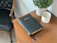 A softly glowing green and white candle placed on a wooden table next to an open Bible.