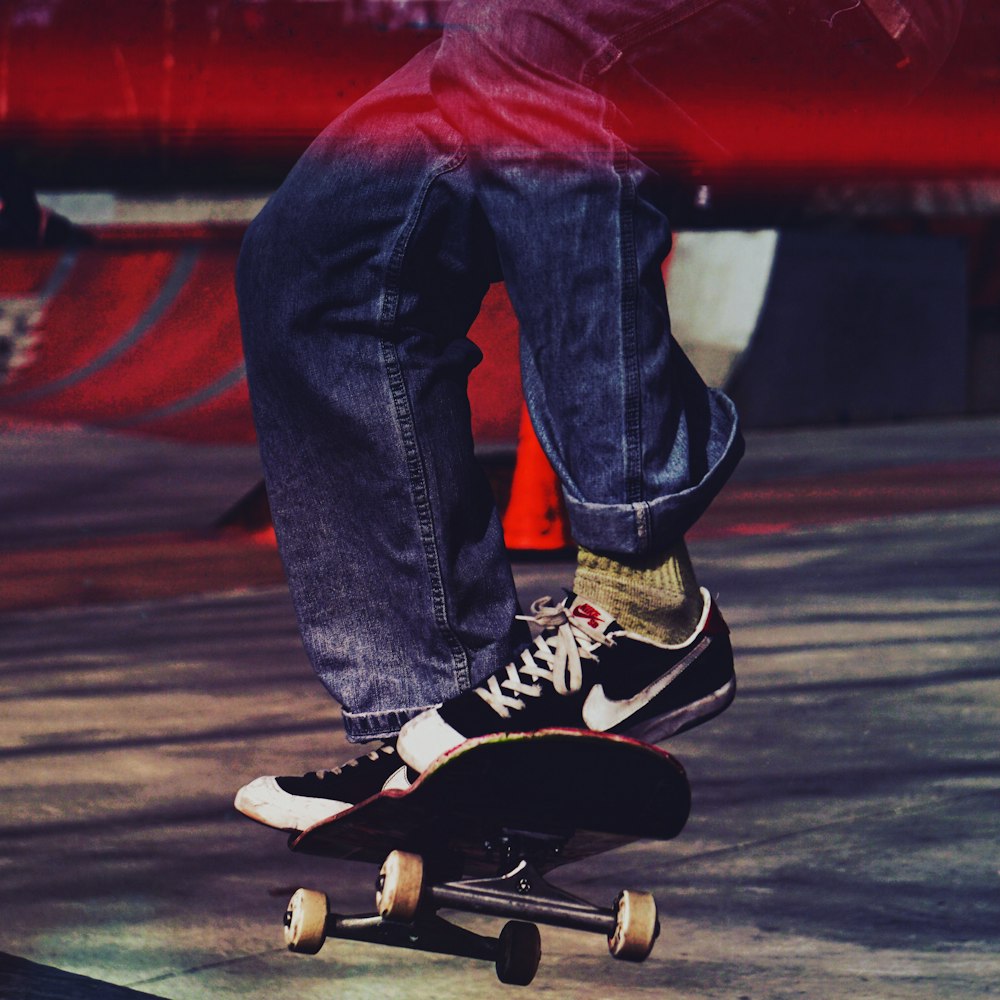 person in blue denim jeans and black and white nike sneakers