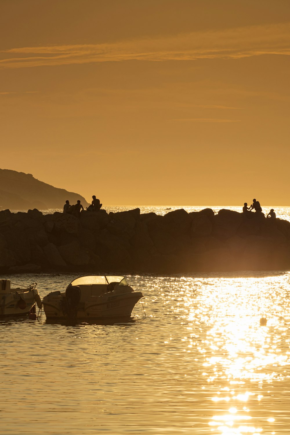 silhouette of people on boat on water during sunset