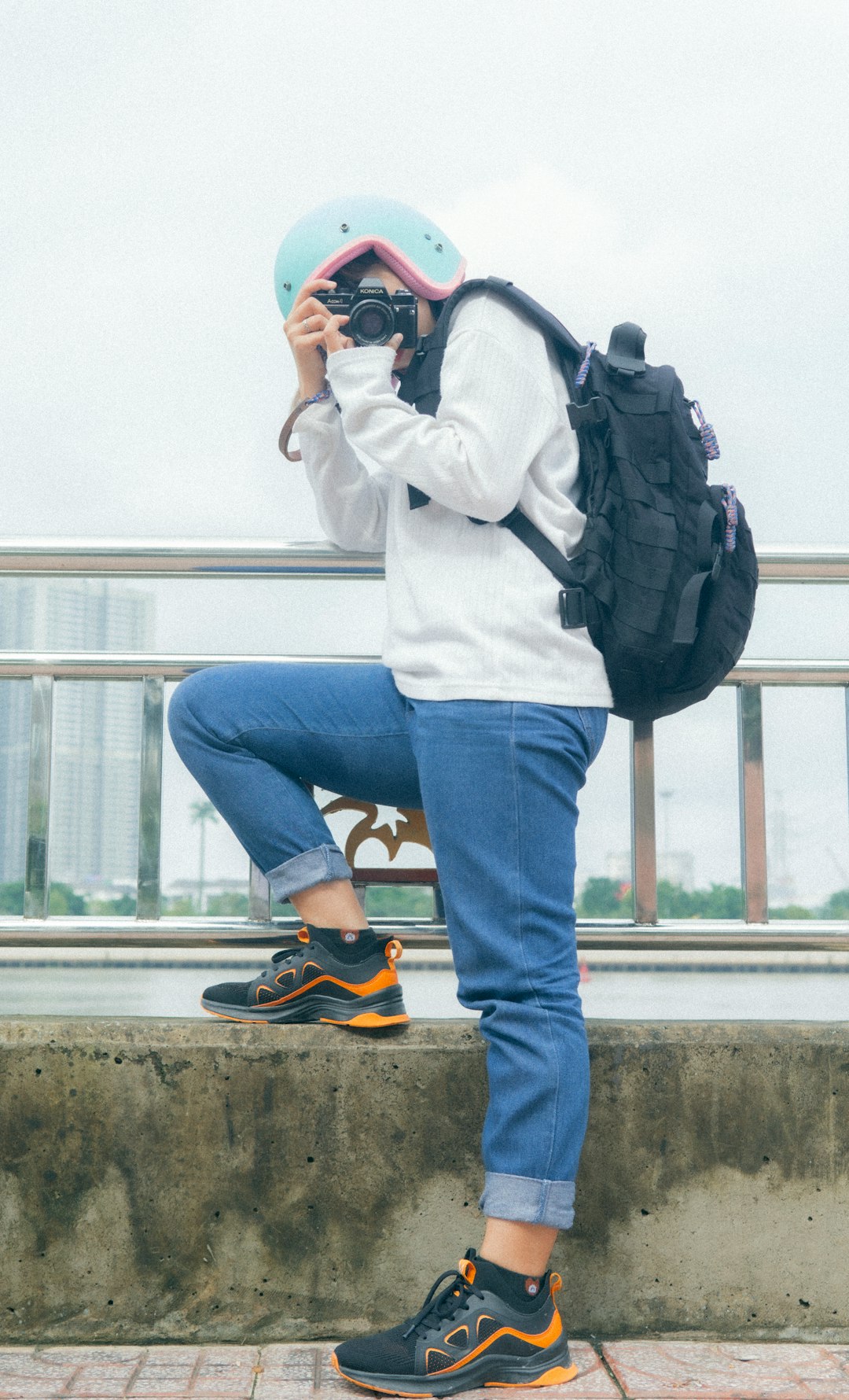 man in white jacket and blue denim jeans sitting on concrete bench