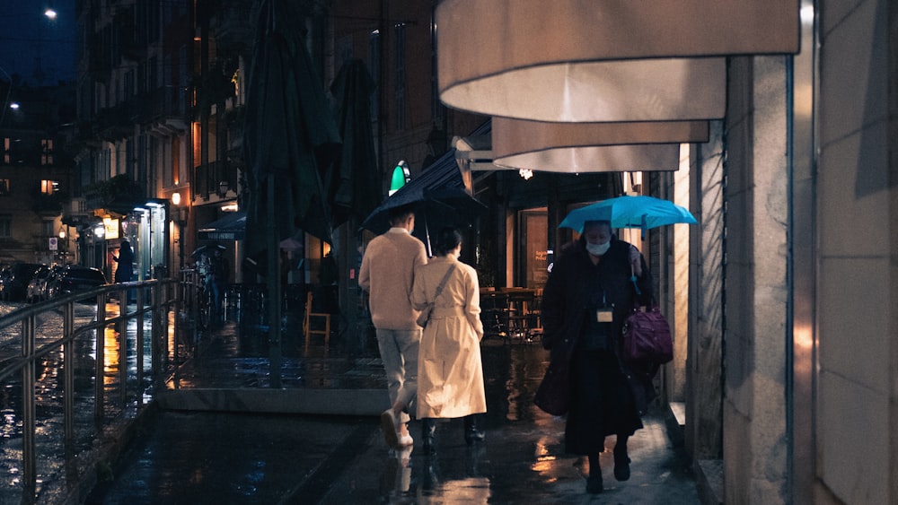 man in white dress shirt and black pants standing on sidewalk during night time