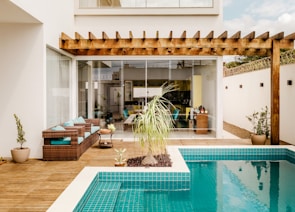 brown wooden table near swimming pool