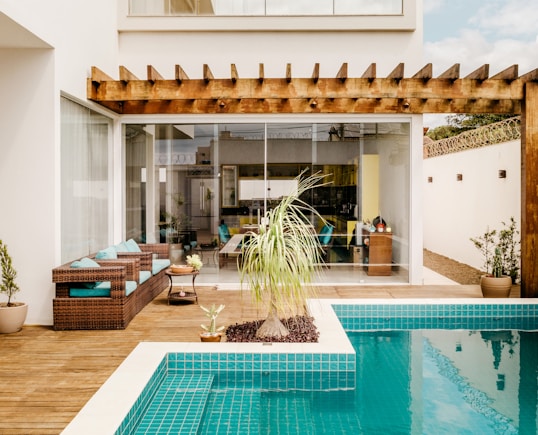 brown wooden table near swimming pool