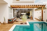 brown wooden table near swimming pool