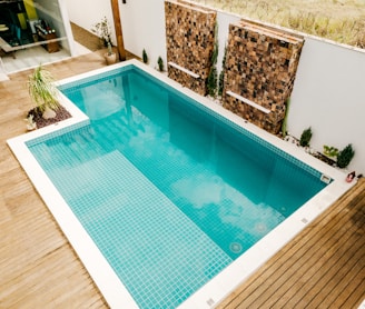 blue swimming pool near green trees during daytime