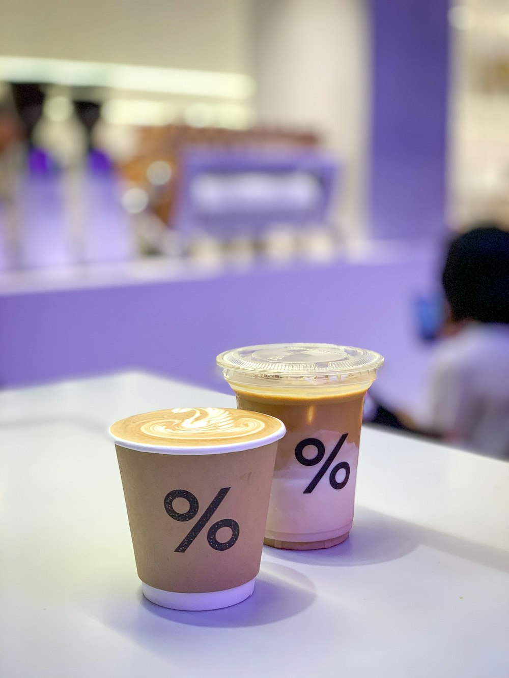 two white and purple disposable cups on white table