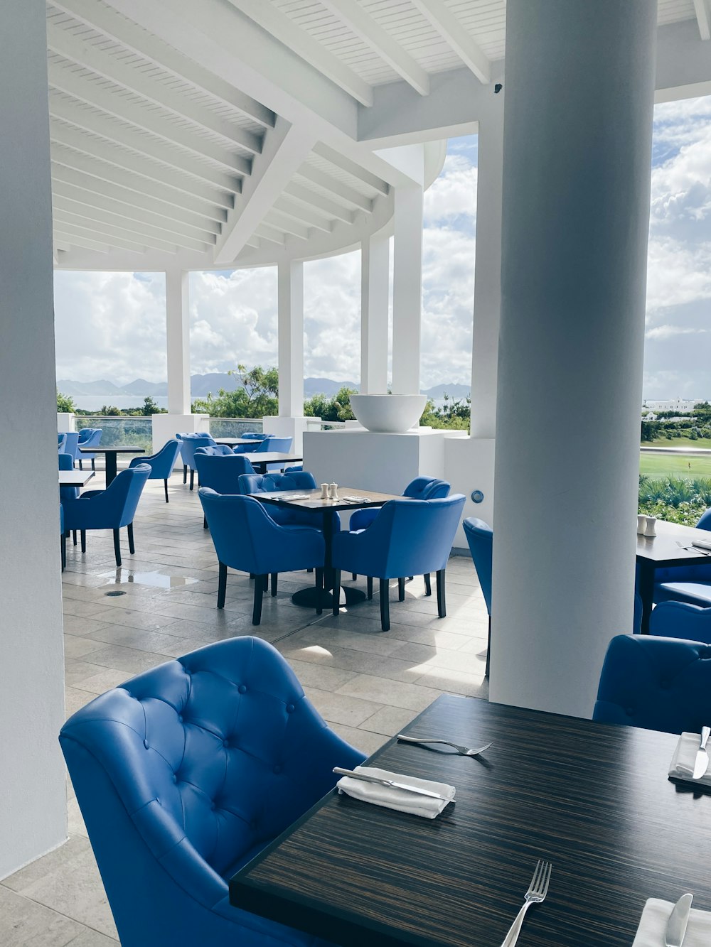 blue chairs and table near glass window