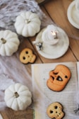 Halloween-themed housewares including spider web coasters and fly-shaped trinket dishes on a dark tabletop.