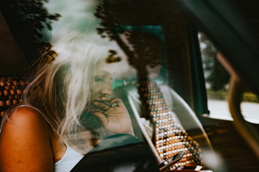 Frau in weißem Tanktop sitzt auf Autositz