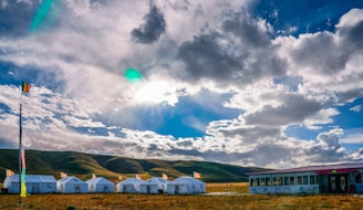 A panoramic view of multiple sanfonada tents arranged neatly for a large outdoor event under a clear sky.