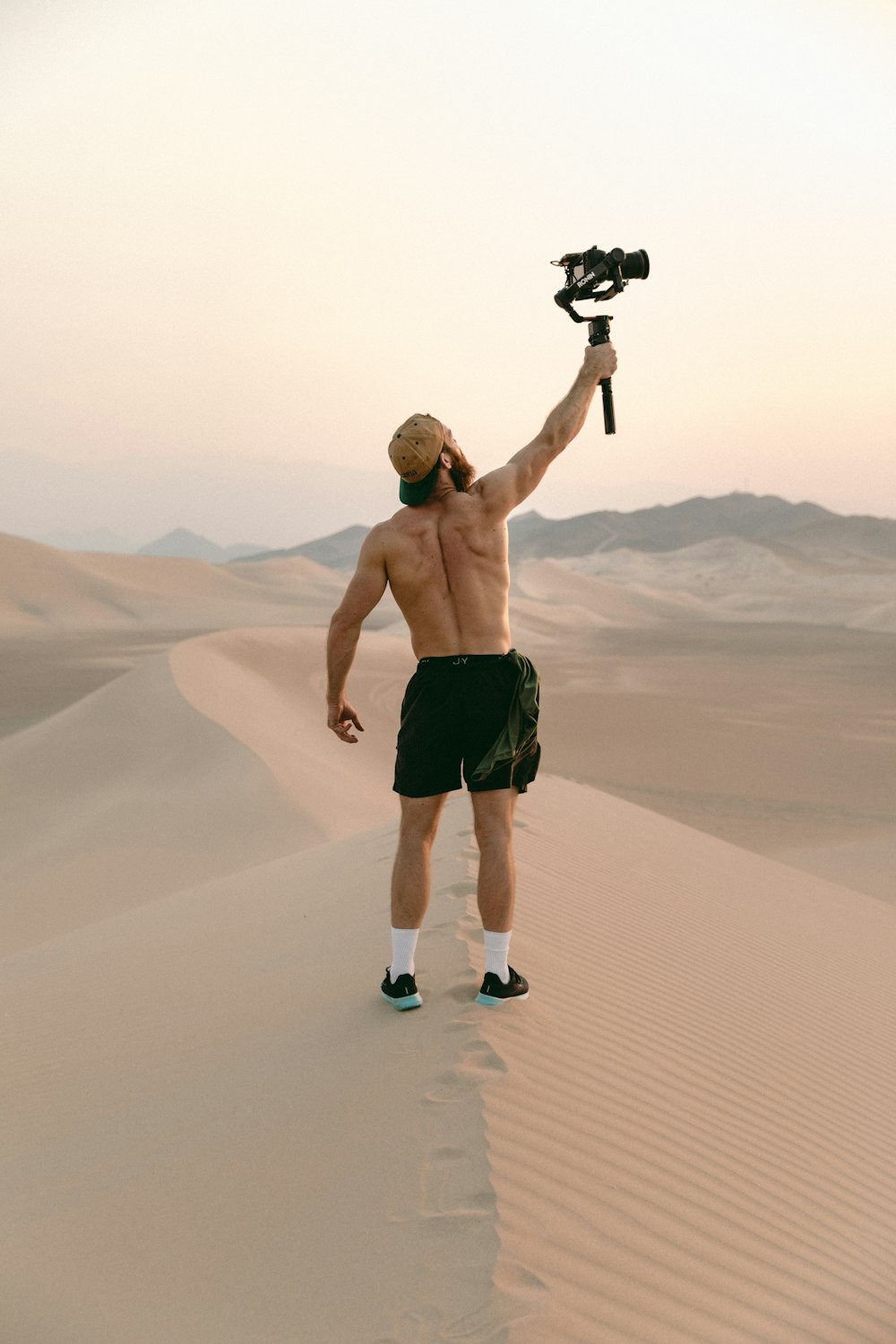 man in black shorts holding black dslr camera