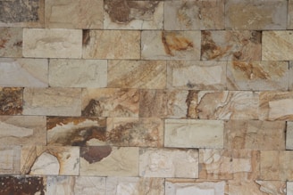 Close-up of textured stone walls blending with warm wooden furniture in a guest room.