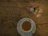 A warm cup of coffee on a wooden table beside a small vase of fresh flowers.