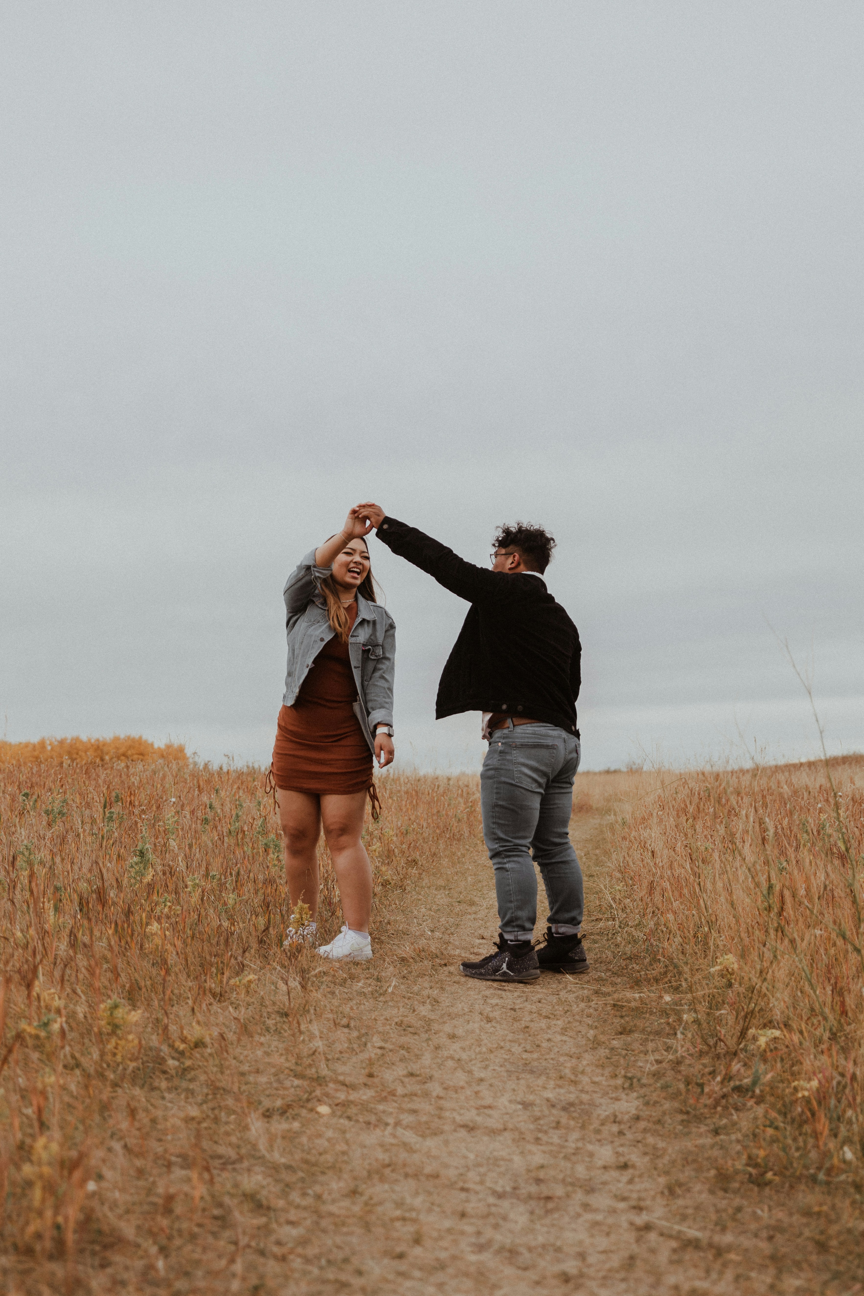 man and woman kissing on brown grass field during daytime