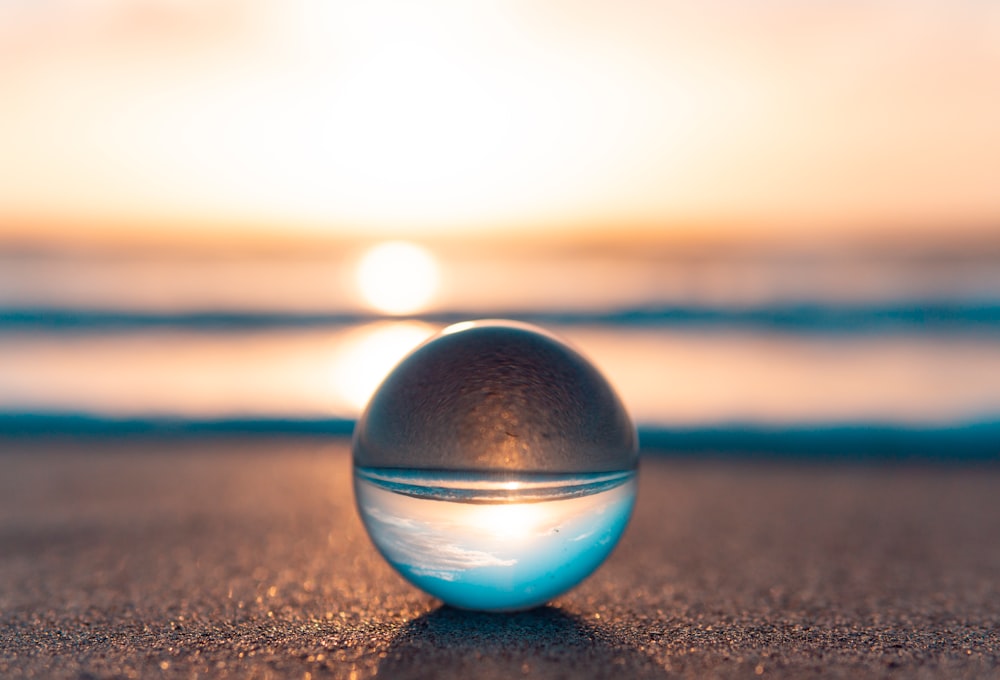 blue and silver ball on black sand