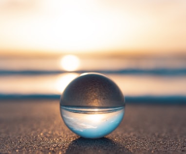 blue and silver ball on black sand