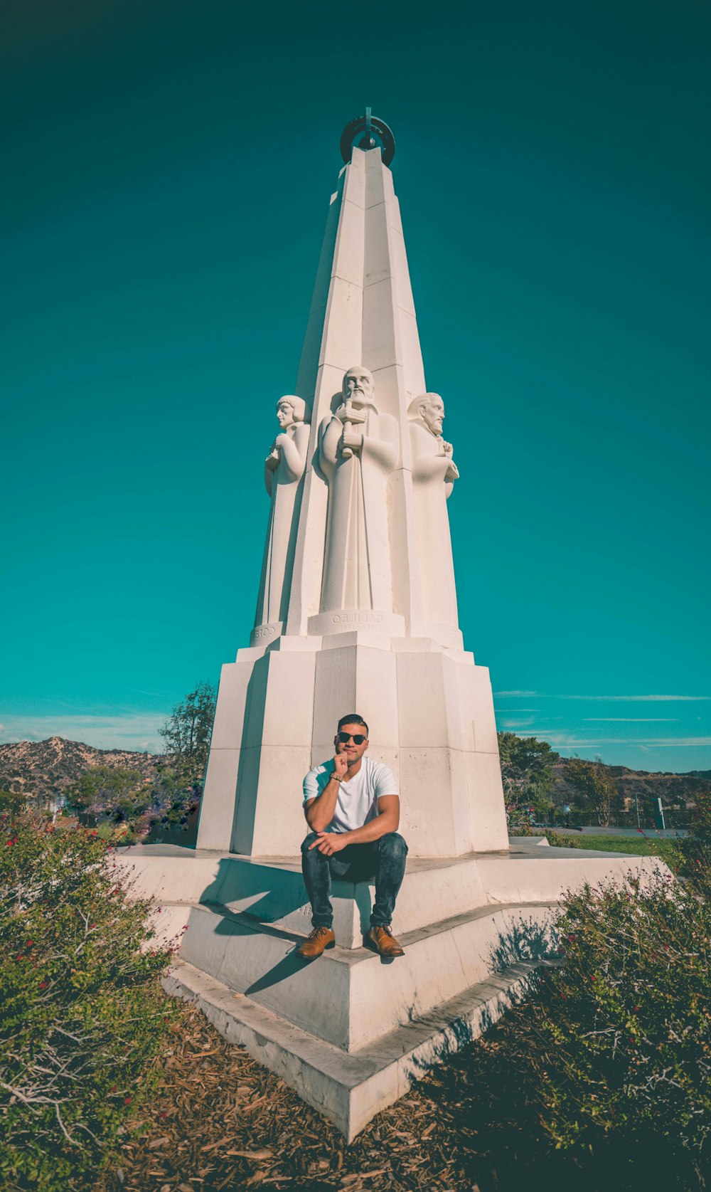 man in black t-shirt sitting on white concrete bench during daytime