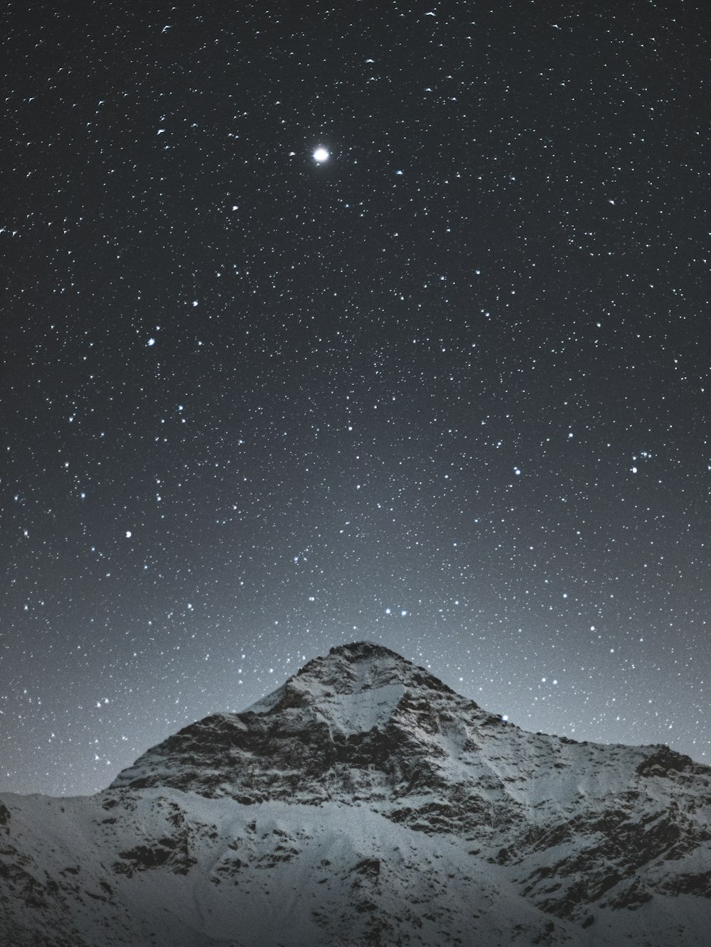 Montaña cubierta de nieve bajo la noche estrellada