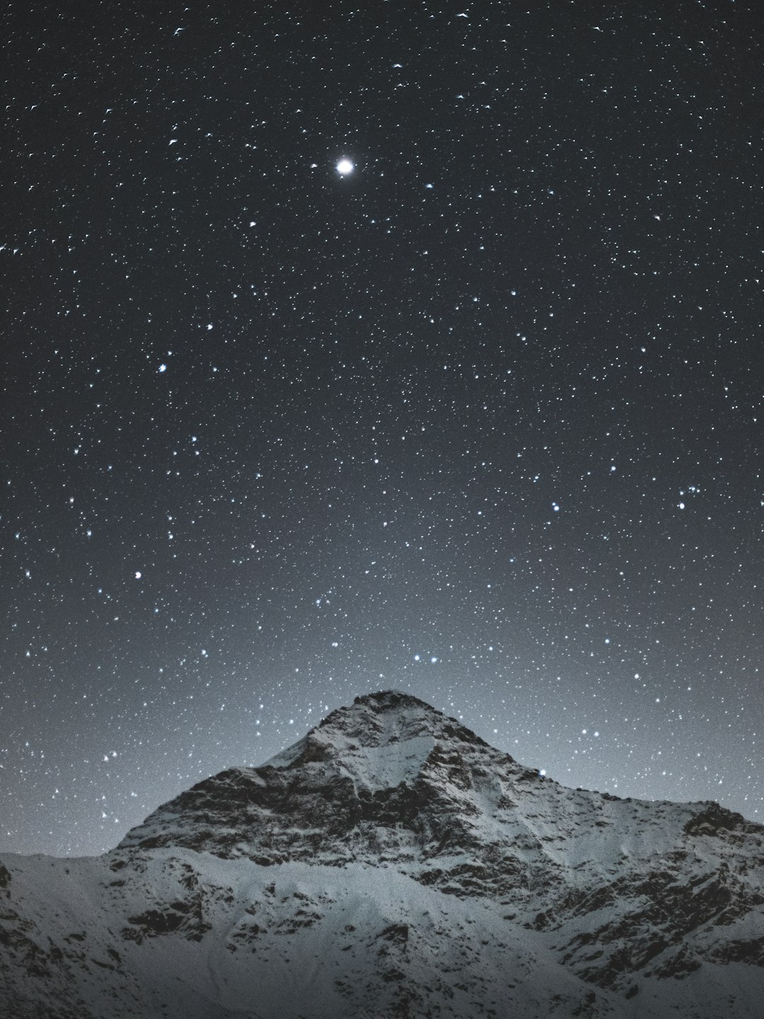 snow covered mountain under starry night