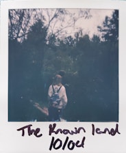 A person hiking with a backpack in a lush green forest.