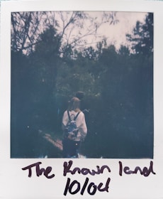 A person hiking with a backpack in a lush green forest.