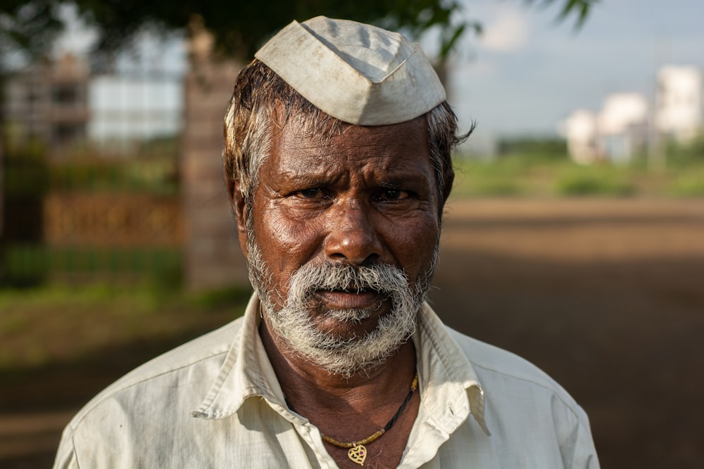 man in white button up shirt wearing white and gray hat