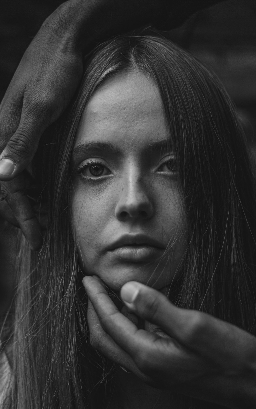 grayscale photo of woman with her hand on her face