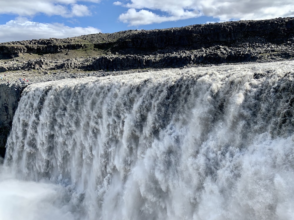 waterfalls near green trees during daytime