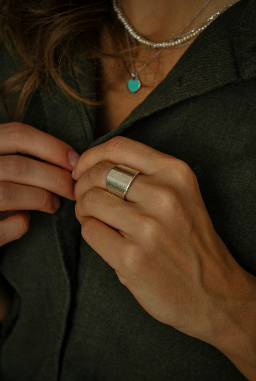 woman wearing silver ring and black coat