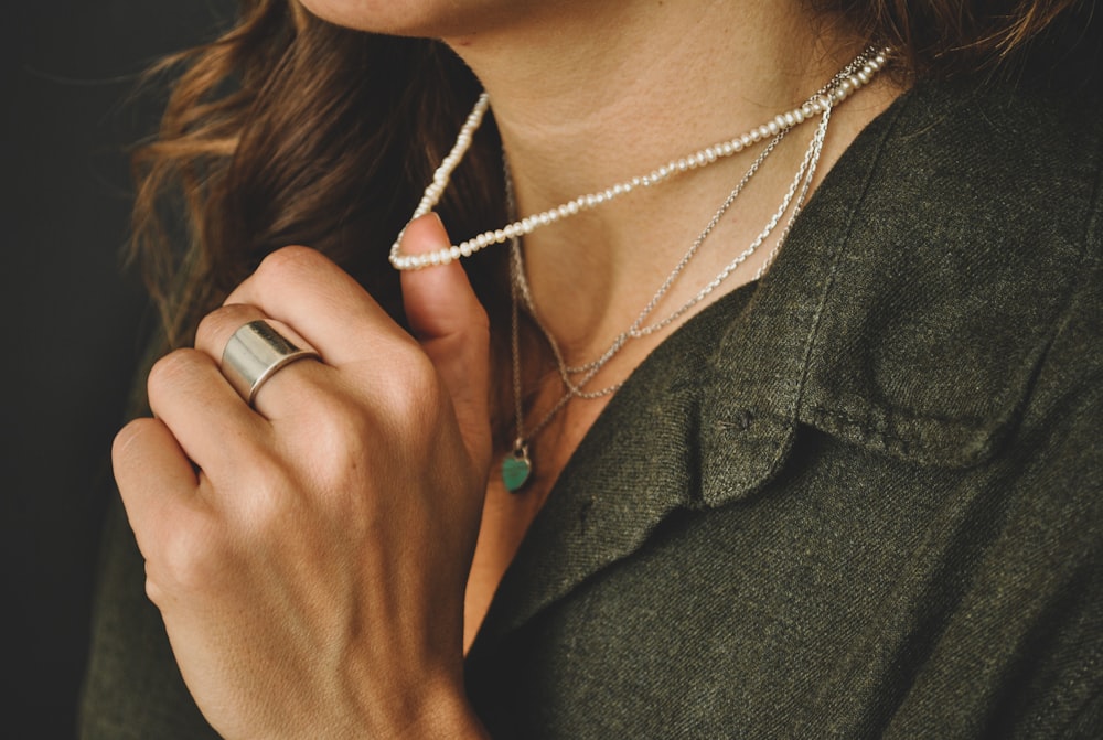 woman in green coat wearing silver necklace