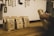 A series of brown paper bags labeled 'Family Farm' with sizes such as small, medium, and large printed on them are placed on a wooden counter. A person's hands are seen arranging one of the bags. In the background, various knives and a power outlet are attached to the wall.