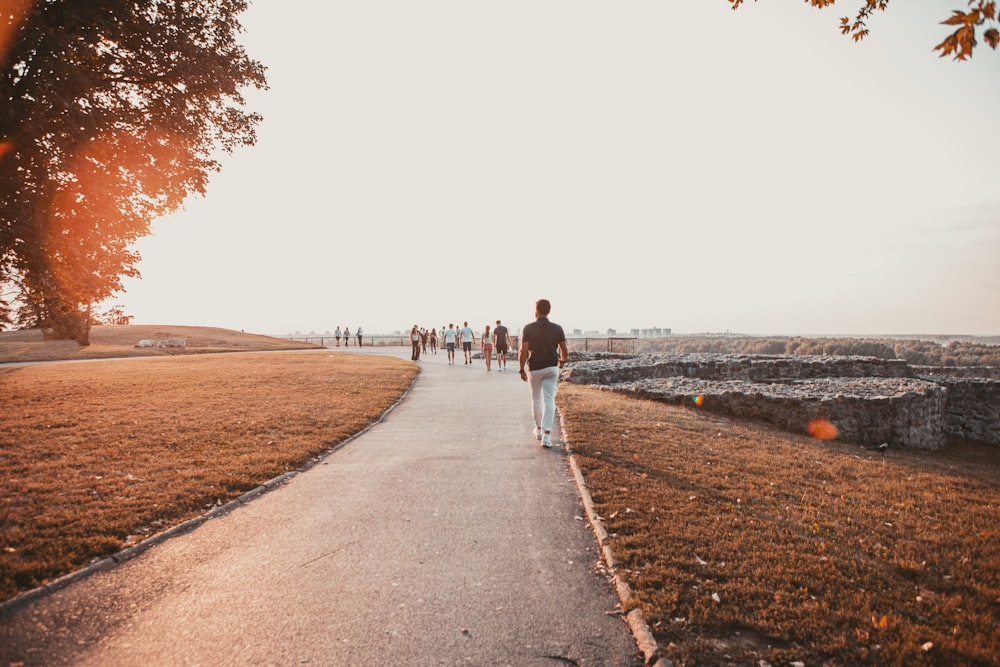 couple walking on gray concrete road during daytime