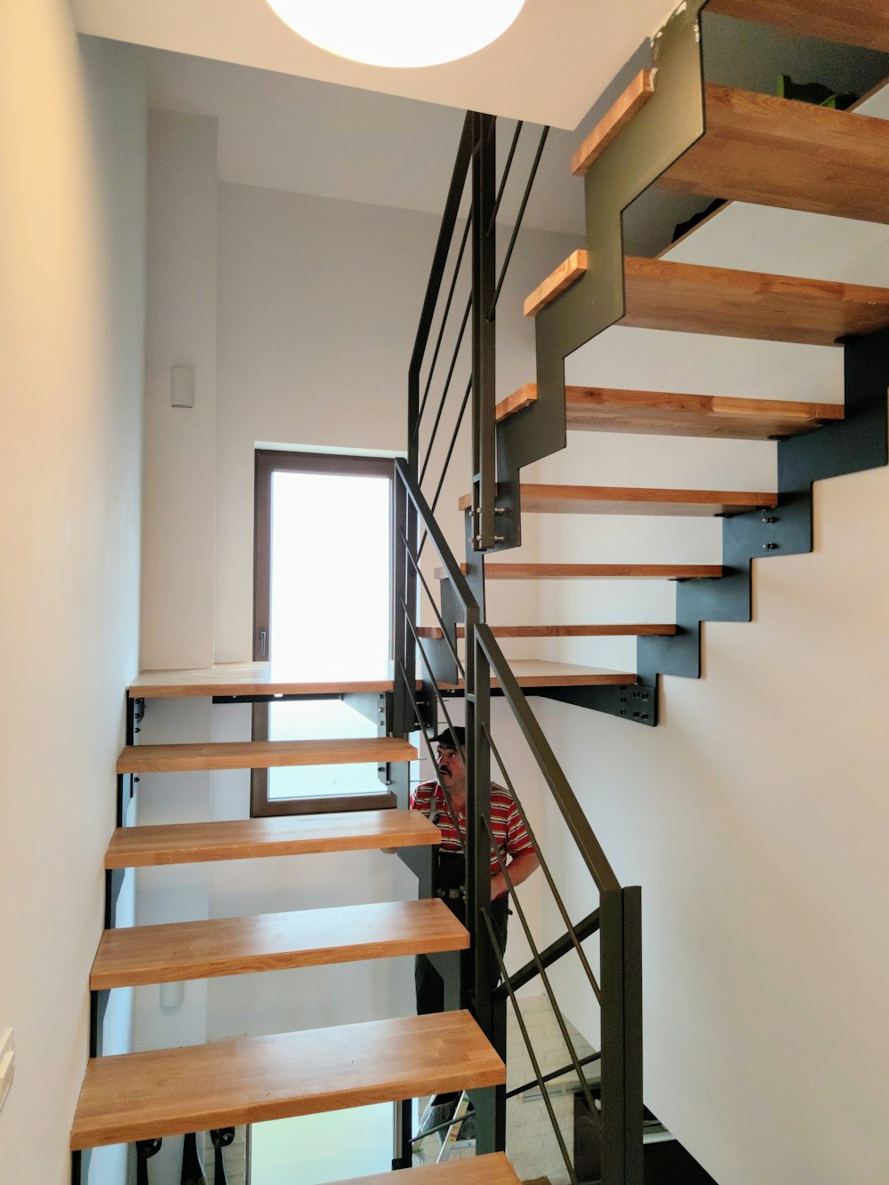 brown wooden staircase near white wall