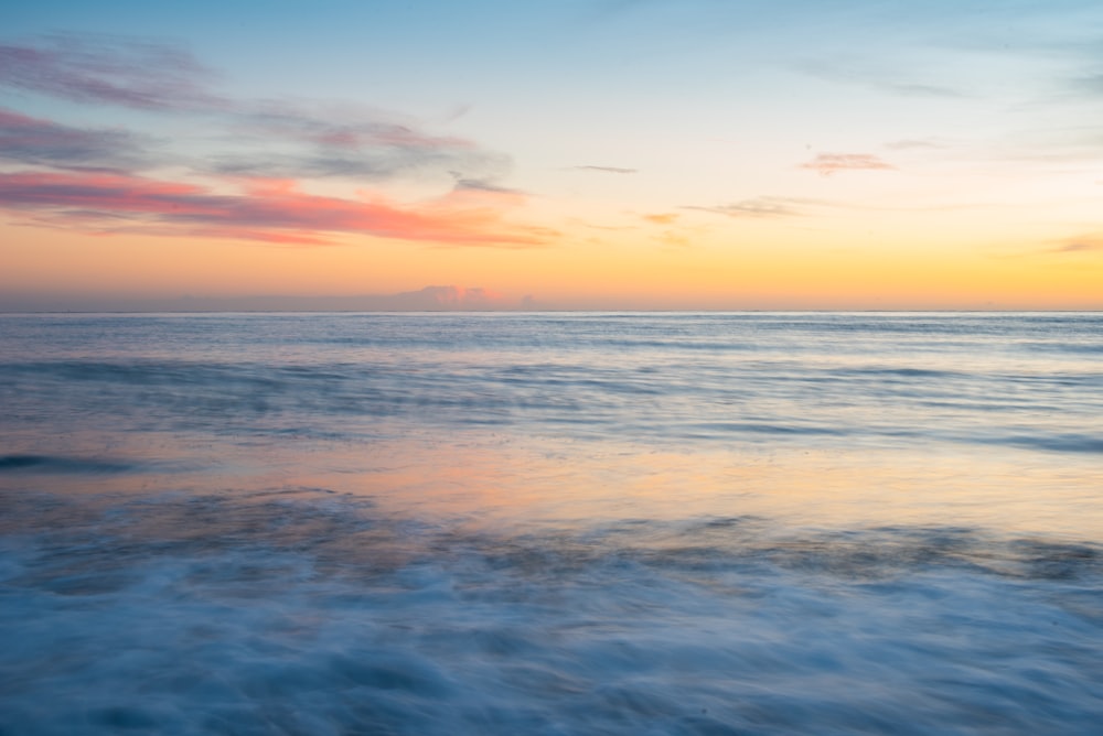 mar azul bajo el cielo azul durante la puesta del sol