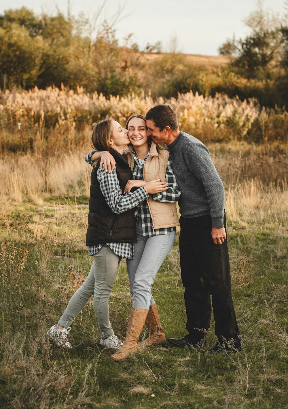 man and woman kissing on grass field during daytime