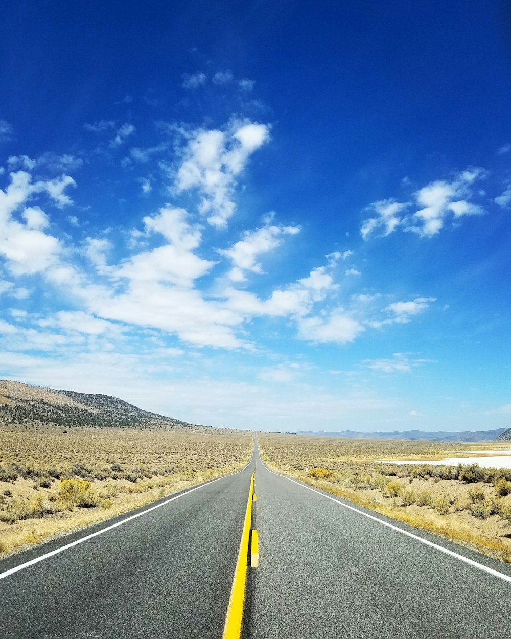 gray asphalt road under blue sky during daytime