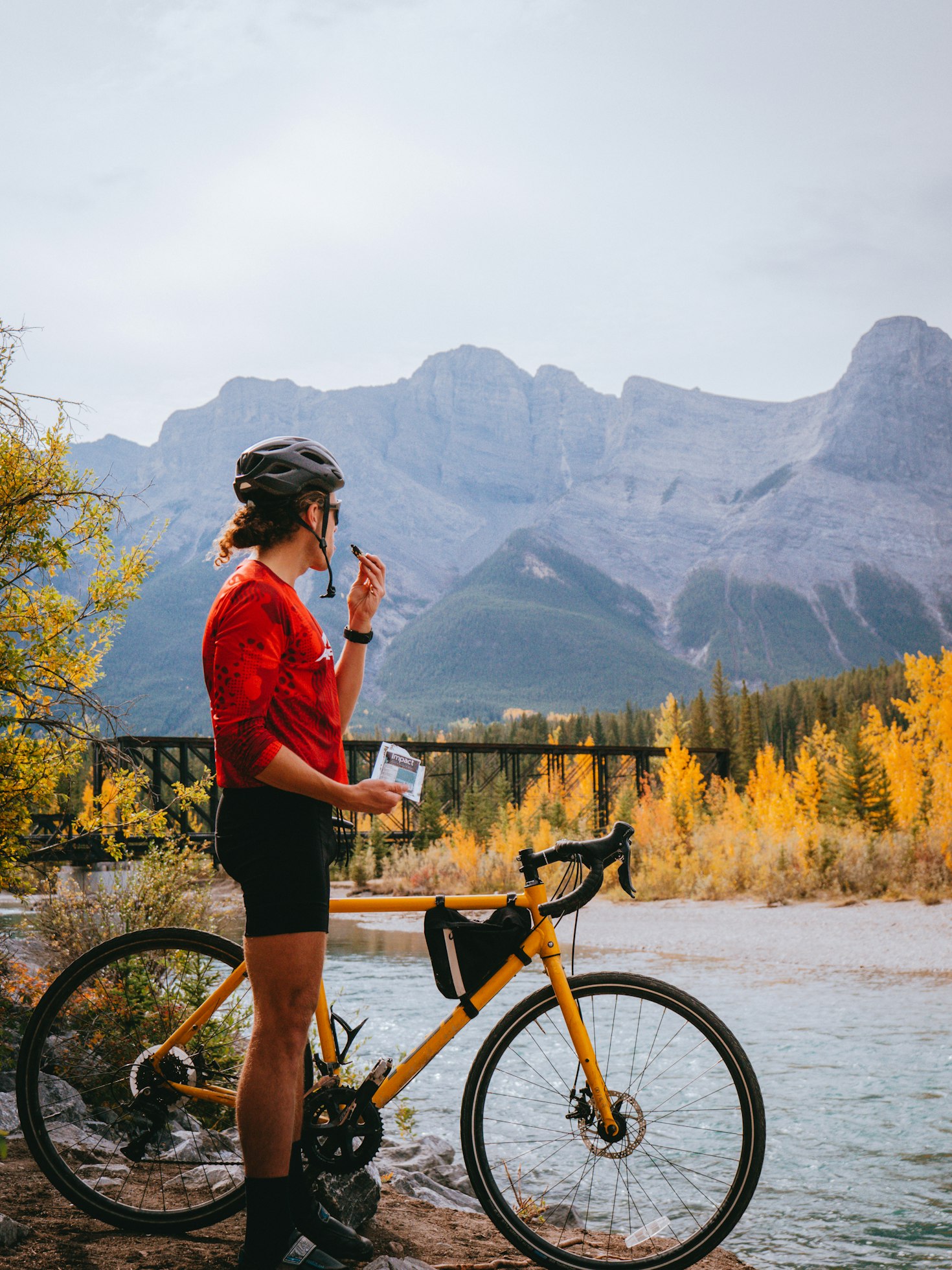 Young woman standing by her gravel bike having a snack