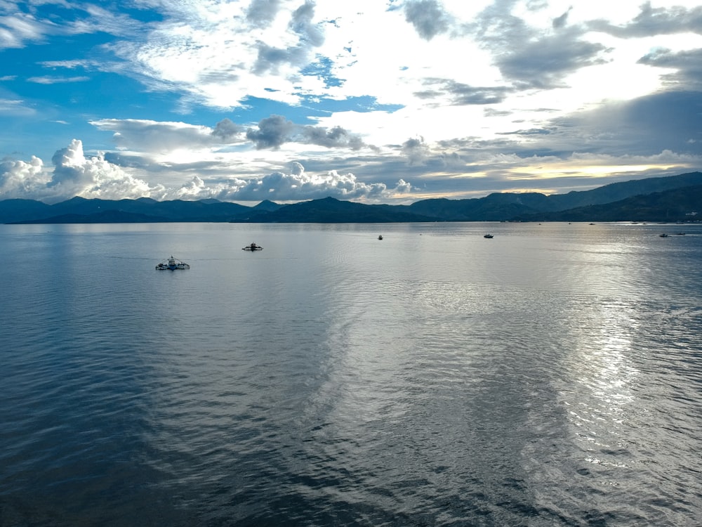 white boat on sea under blue sky during daytime