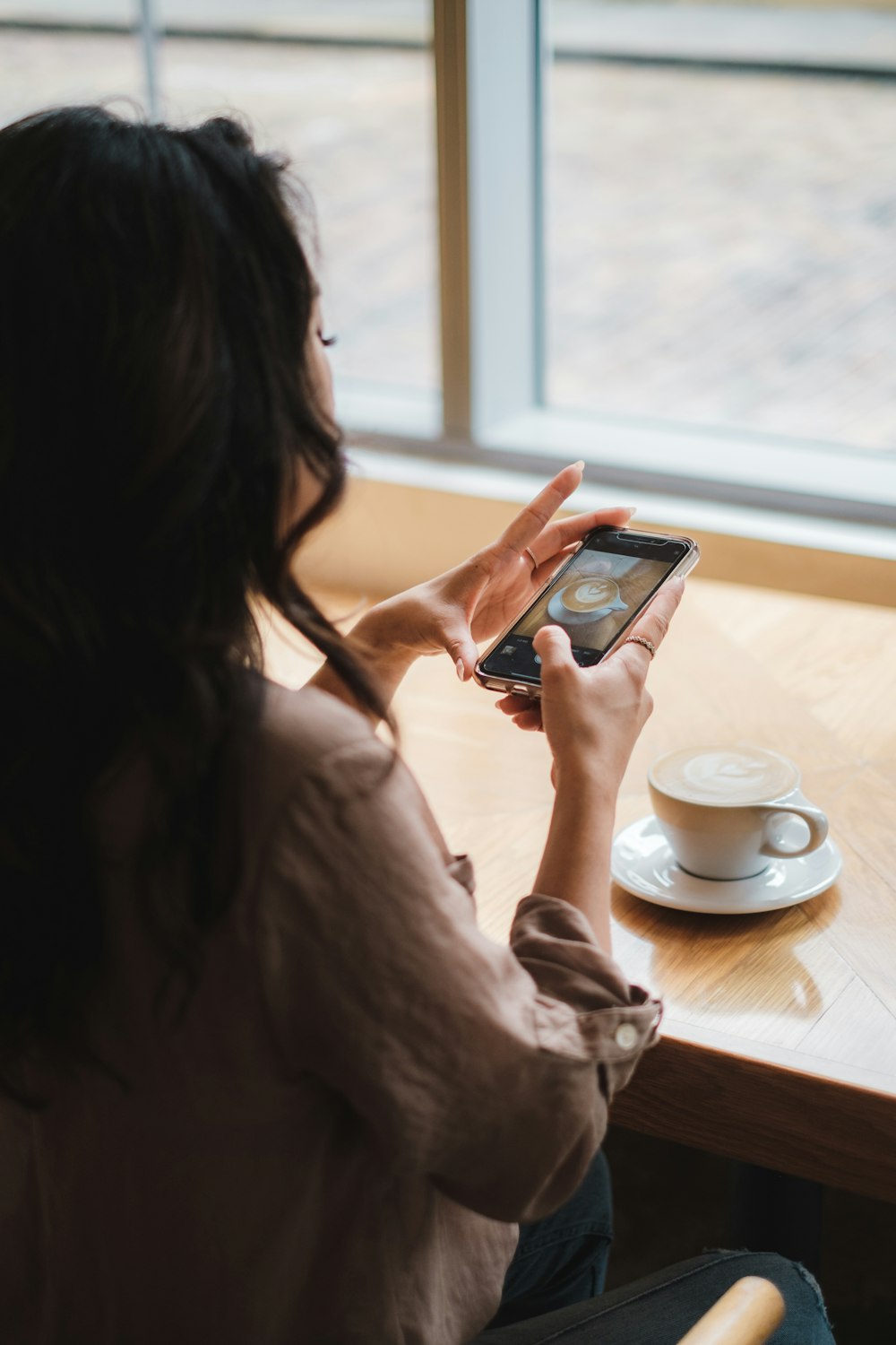 mulher no vestido branco que segura o smartphone preto