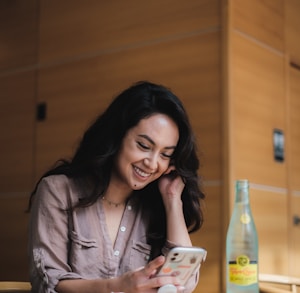 woman in gray button up shirt holding white ceramic mug