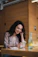 Smiling woman holding a bottle of molecular hydrogen product in a bright kitchen