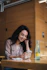 Smiling woman holding a bottle of molecular hydrogen product in a bright kitchen