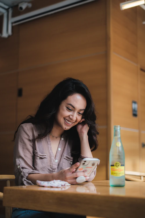 Invitée souriante qui ouvre son invitation sur téléphone